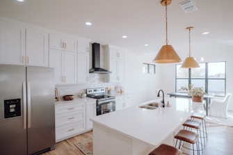 a kitchen with white cabinets and a silver refrigerator