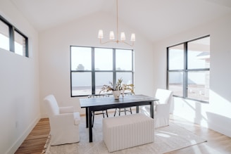 a dining room with a black table and white chairs