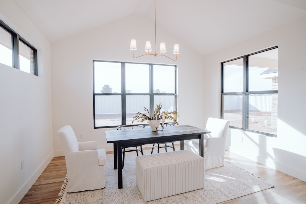 a dining room with a black table and white chairs