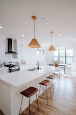 a large kitchen with a center island and bar stools