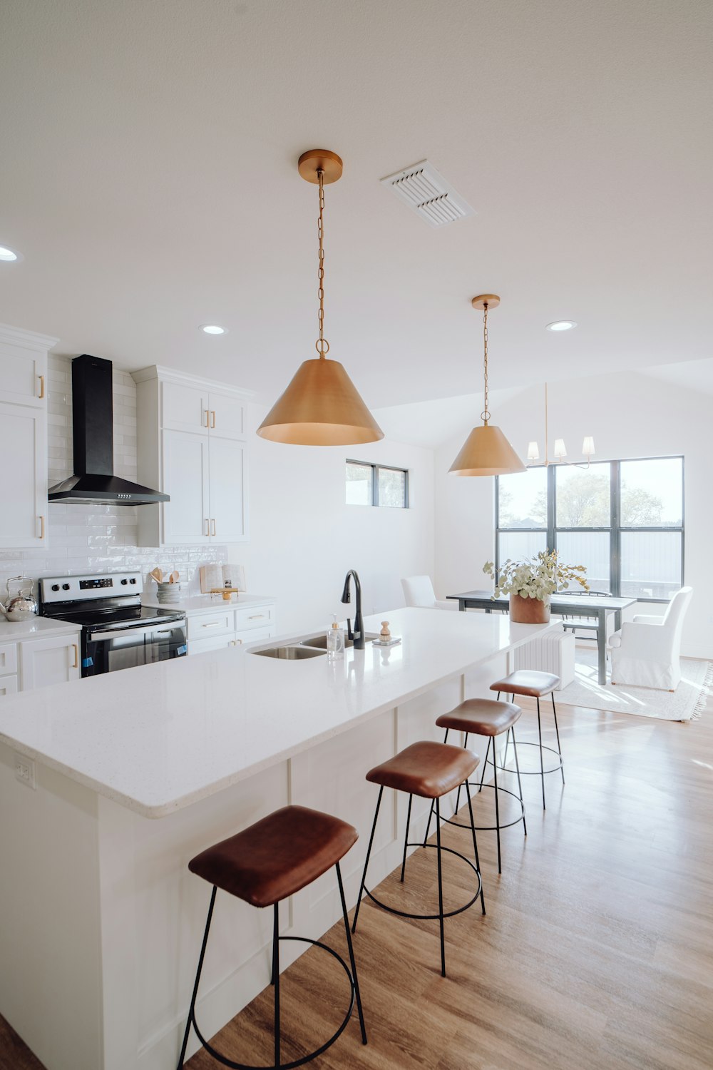 a large kitchen with a center island and bar stools