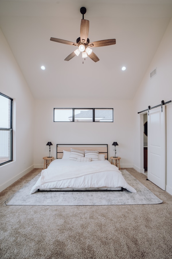 a bedroom with a bed and a ceiling fanby Bailey Alexander