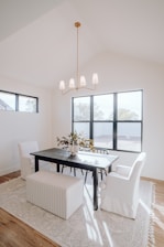 a dining room with a table, chairs, and a bench
