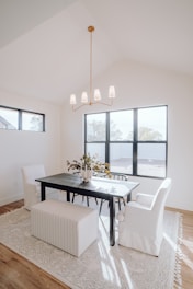 a dining room with a table, chairs, and a bench