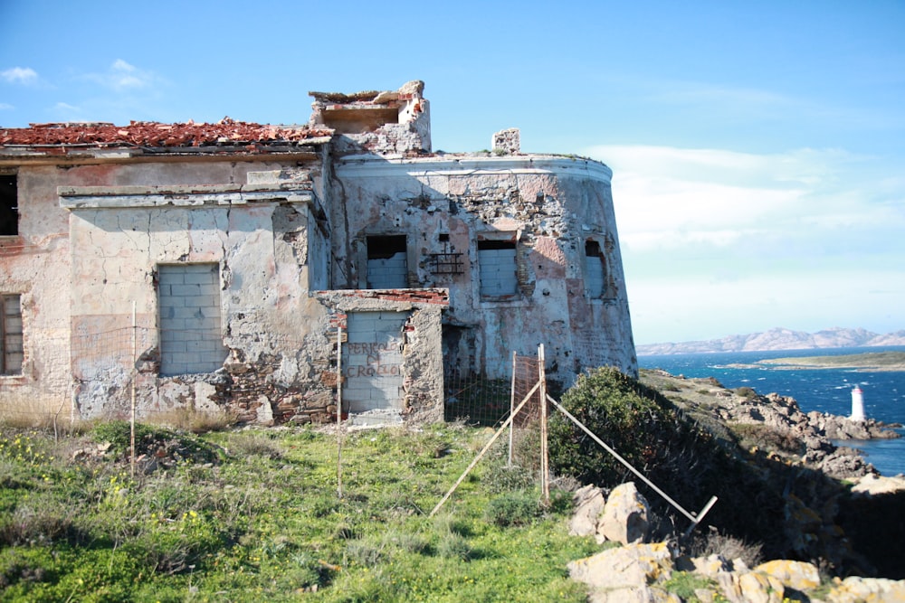 an old building sitting on top of a hill next to a body of water