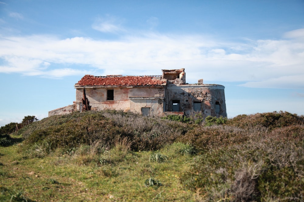 an old abandoned building sitting on top of a hill