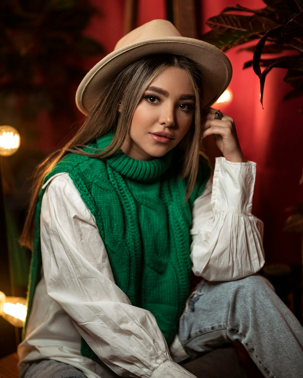 a woman wearing a green sweater and a hat