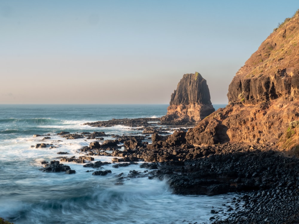 a rocky cliff overlooks a body of water