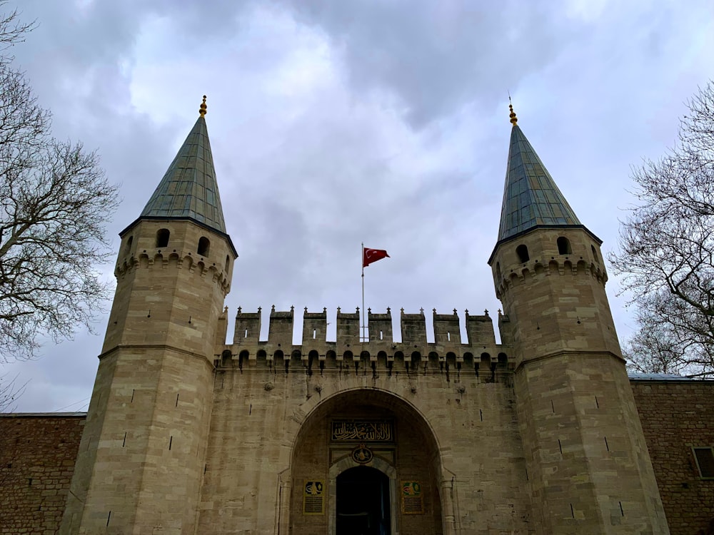 a castle with two towers and a flag on top