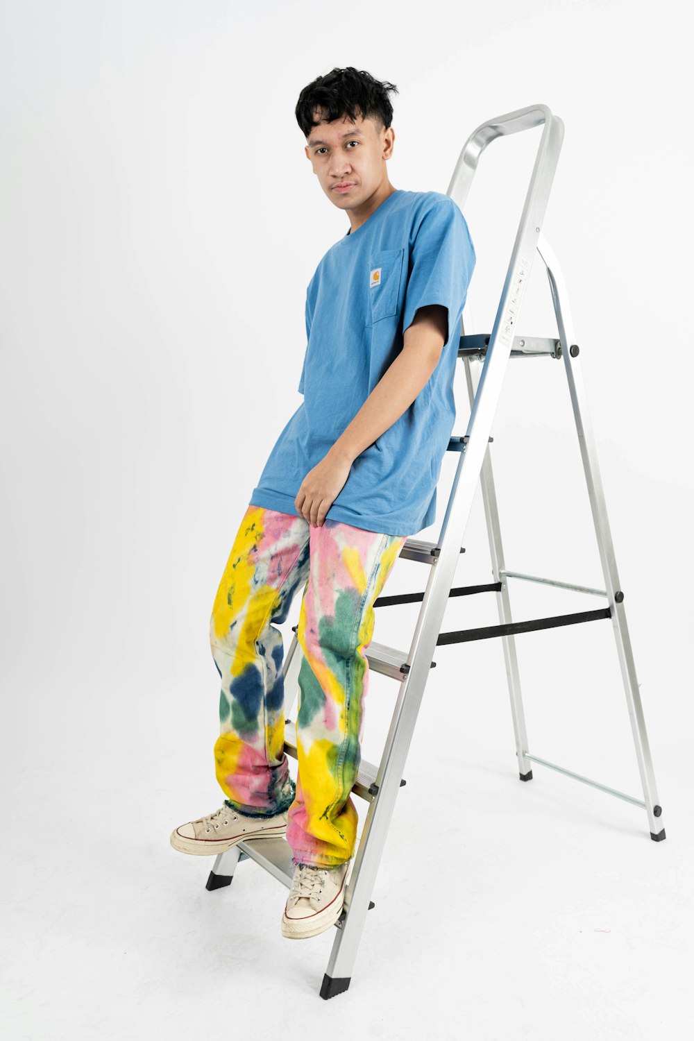 a young boy sitting on a step ladder