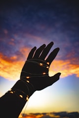 Hands releasing glowing light into the sky symbolizing manifestation.