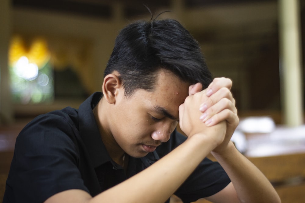 a man sitting at a table with his hands on his head