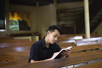 a man sitting in a church reading a book
