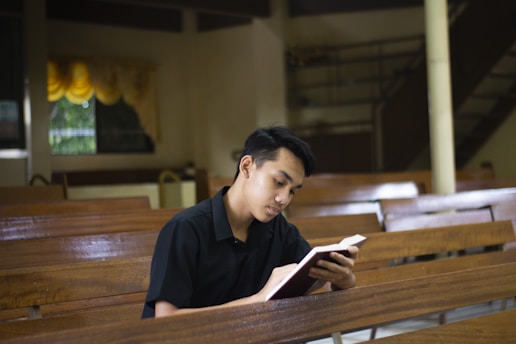 a man sitting in a church reading a book