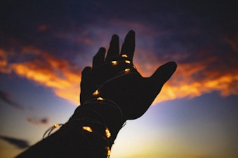 a hand with a string of lights on it