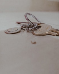 Close-up of various smart keys and remote fobs laid out on a wooden workbench.