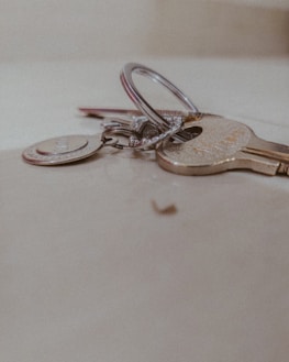 Close-up of a hand holding a set of keys over a white and dark gray background with red accents.