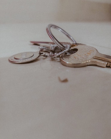 Close-up of a set of shiny house keys on a dark blue background.