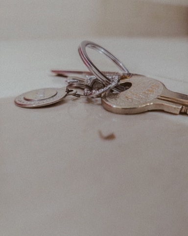 Close-up of various smart keys and remote fobs laid out on a wooden workbench.
