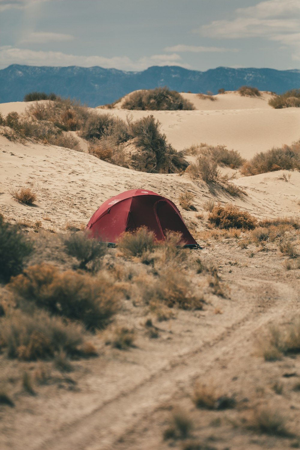 a red tent sitting in the middle of a desert