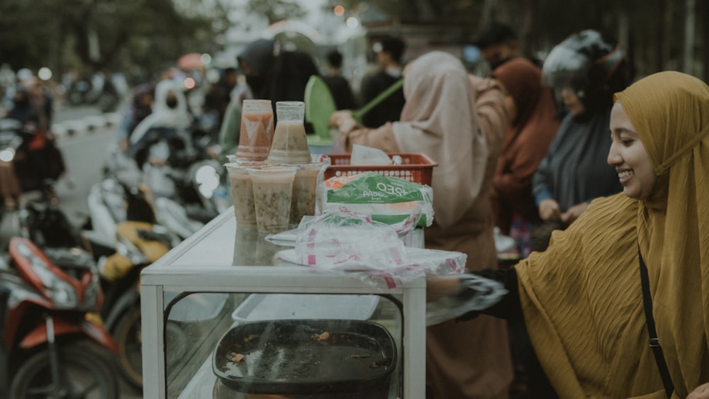 a woman standing in front of a table with food on it