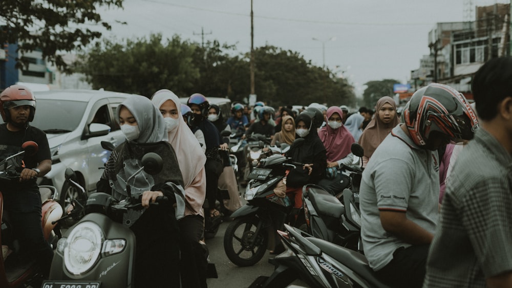 Eine Gruppe von Menschen, die mit dem Motorrad eine Straße entlang fahren