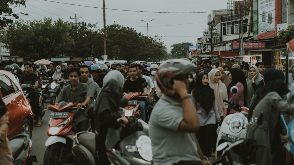 a group of people riding motorcycles down a street