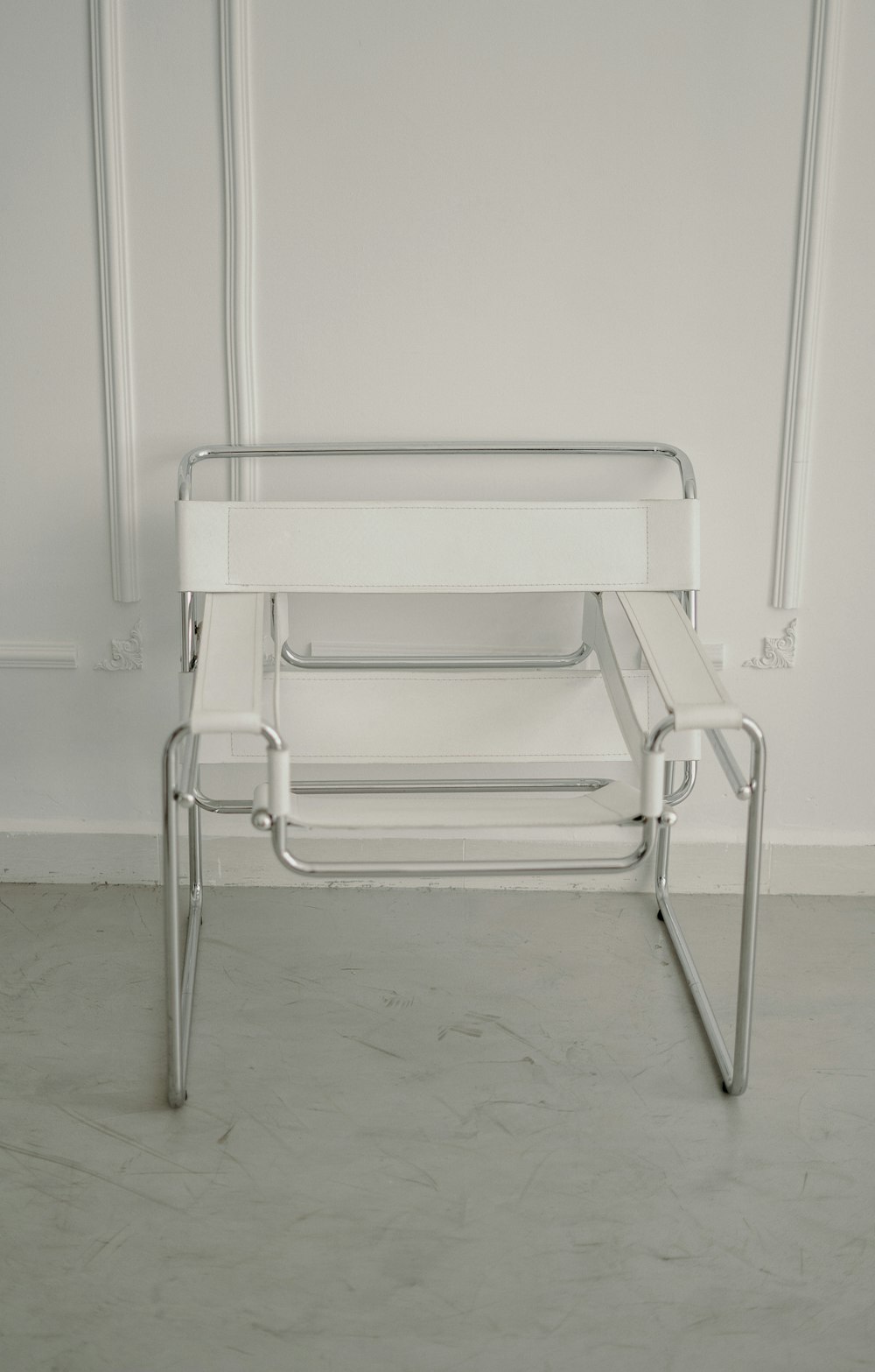 a white chair sitting in front of a white wall