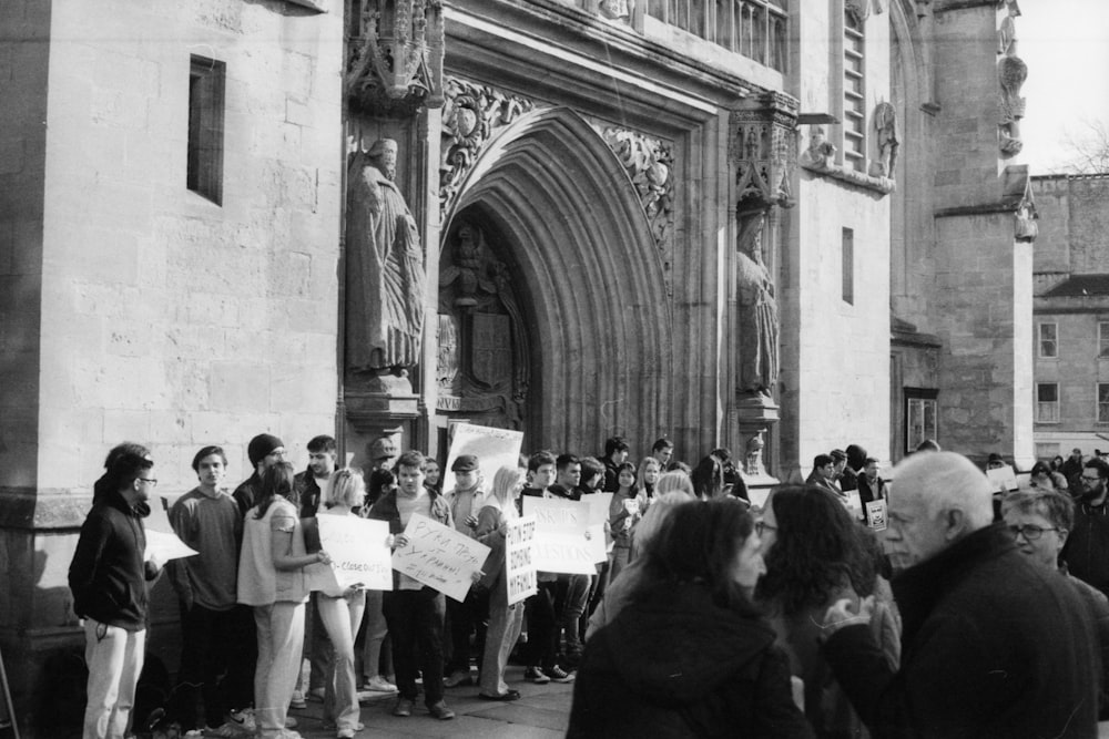 a group of people holding signs in front of a building