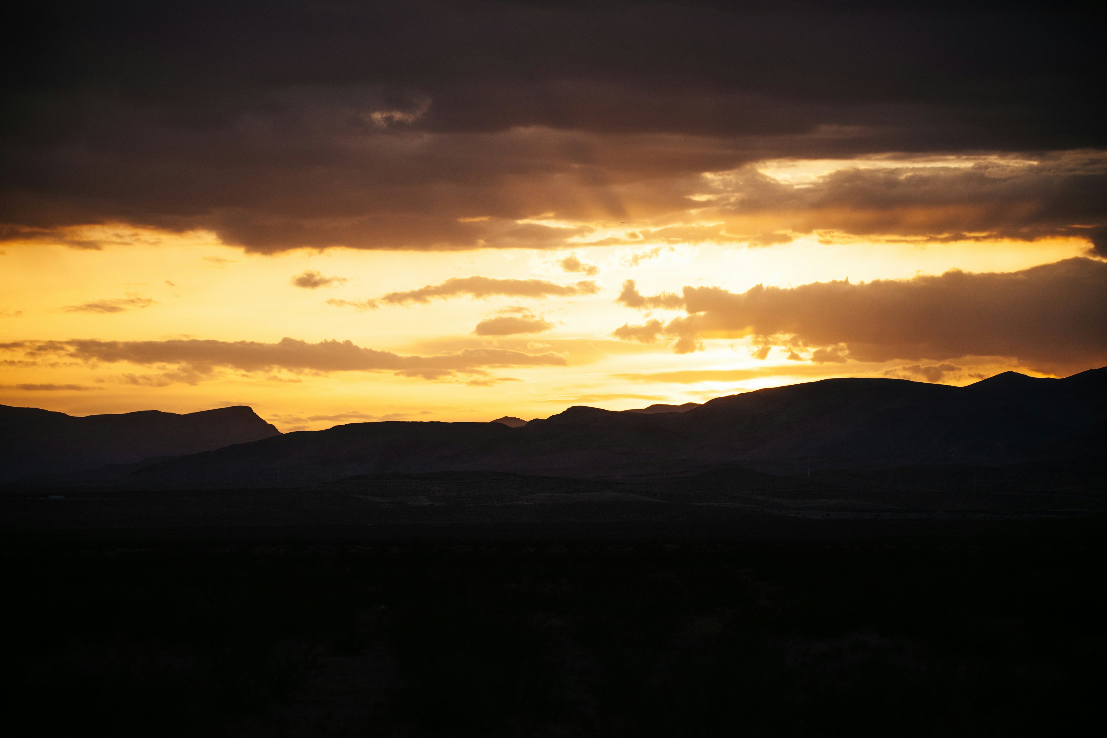 the sun is setting over a mountain range, 