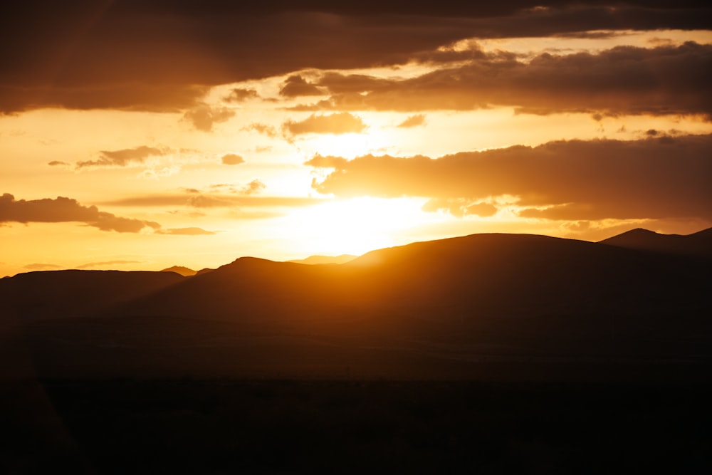 Il sole sta tramontando su una catena montuosa