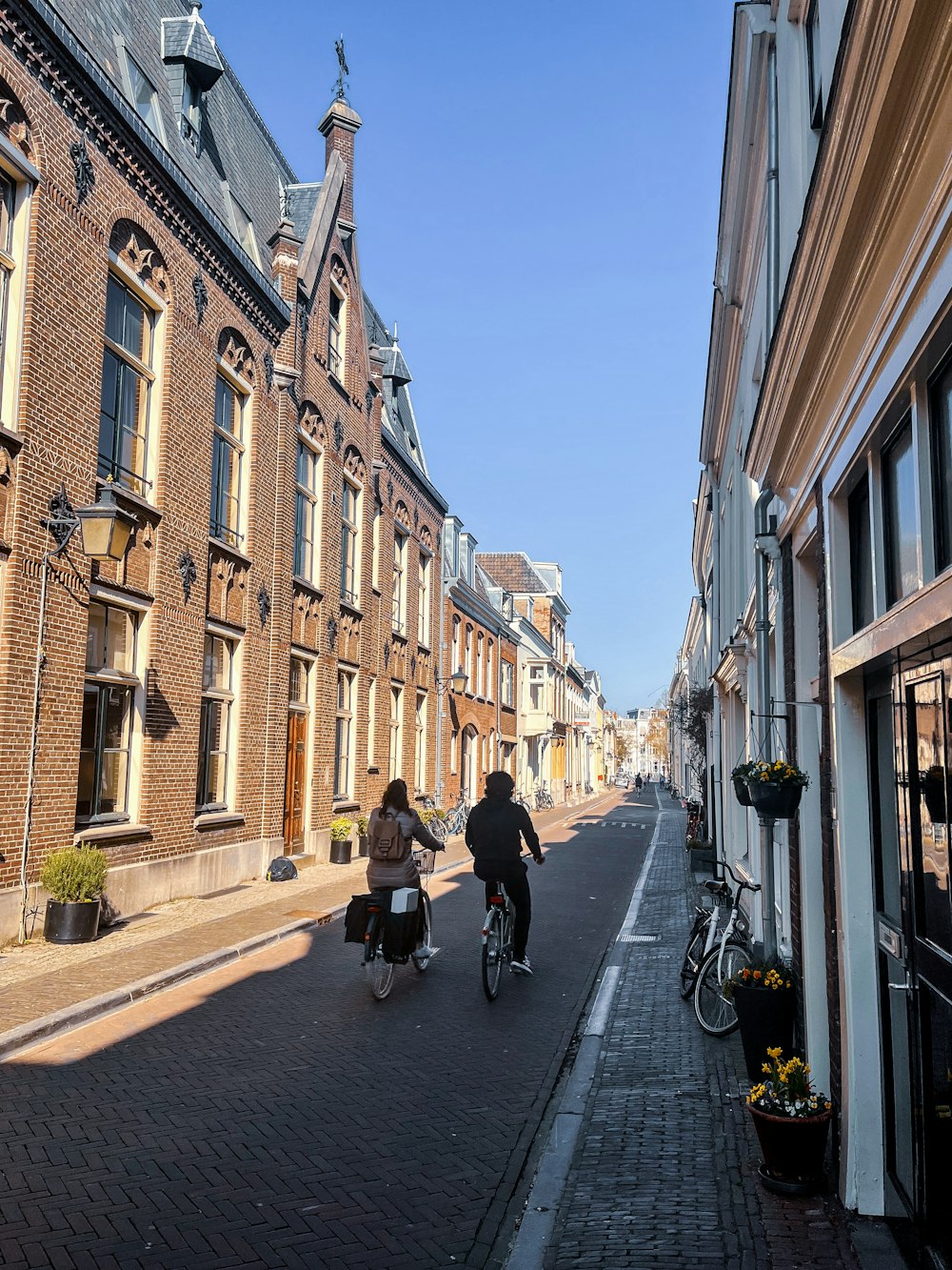 a couple of people riding bikes down a street