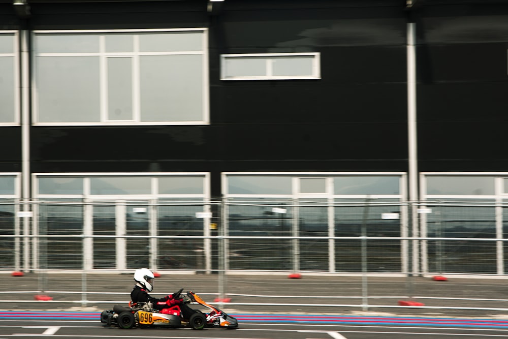 a person riding a go kart in a parking lot