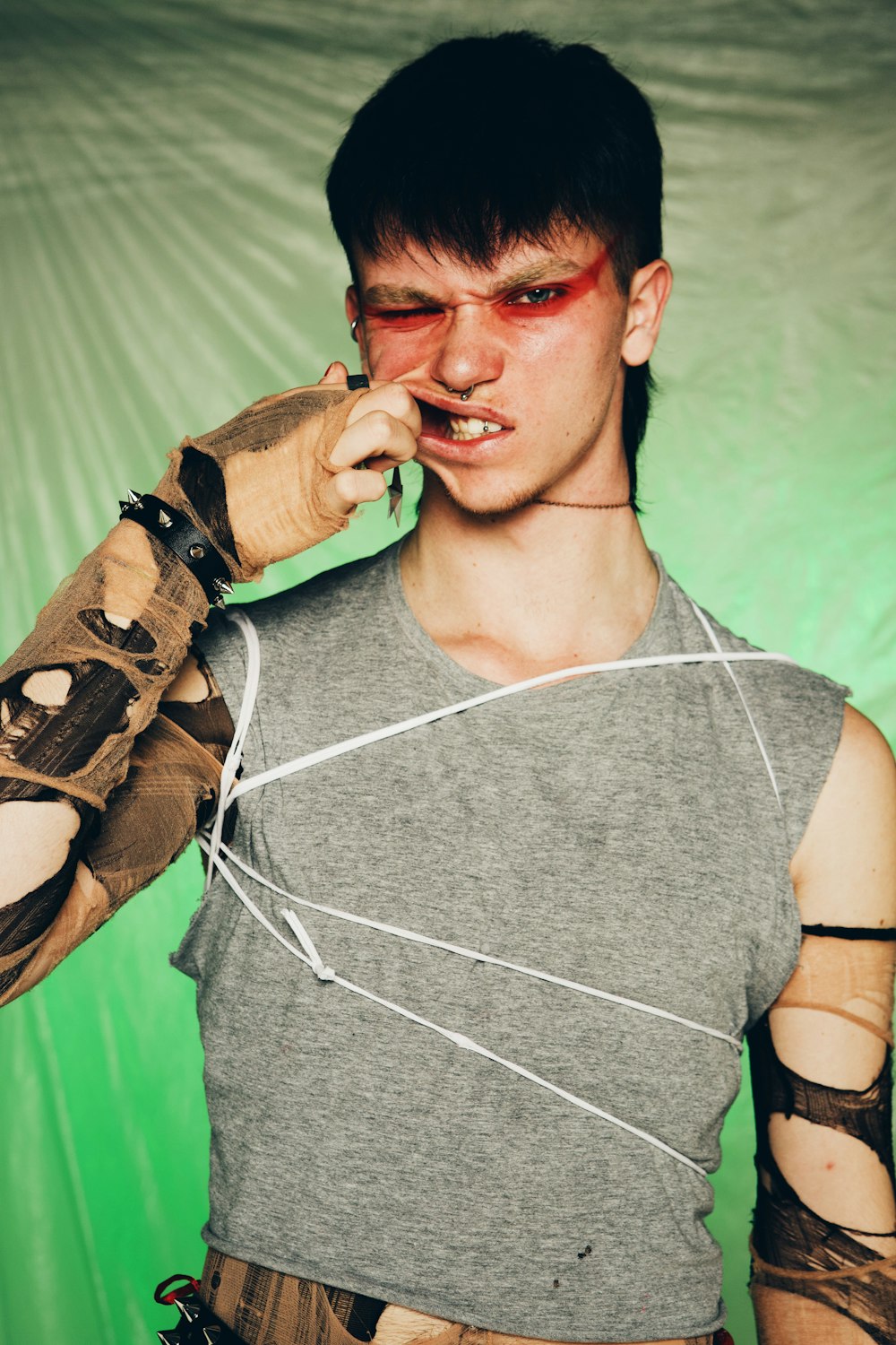 a young man wearing a mask and holding a cell phone to his ear