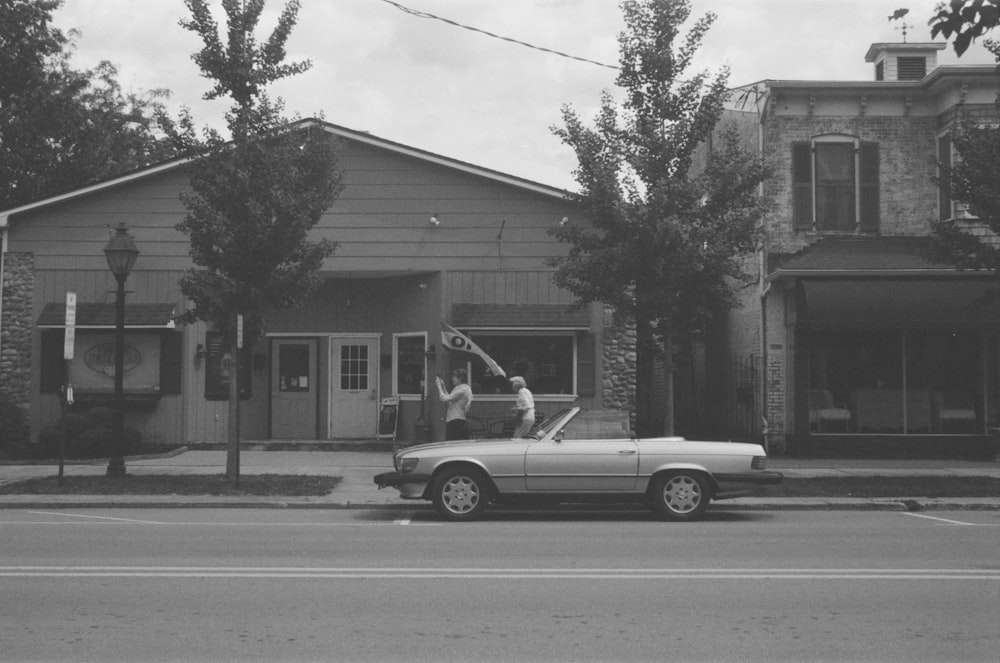 a car parked on the side of a road next to a building