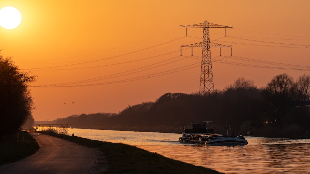 a boat traveling down a river at sunset