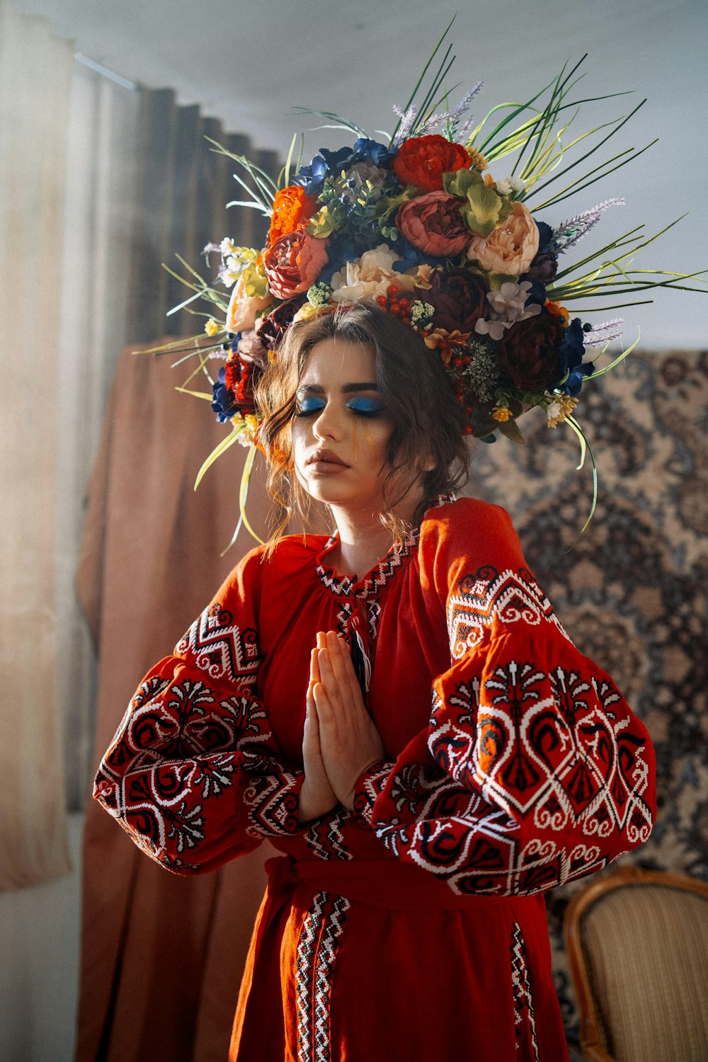 a woman in a red dress with a flower crown on her head