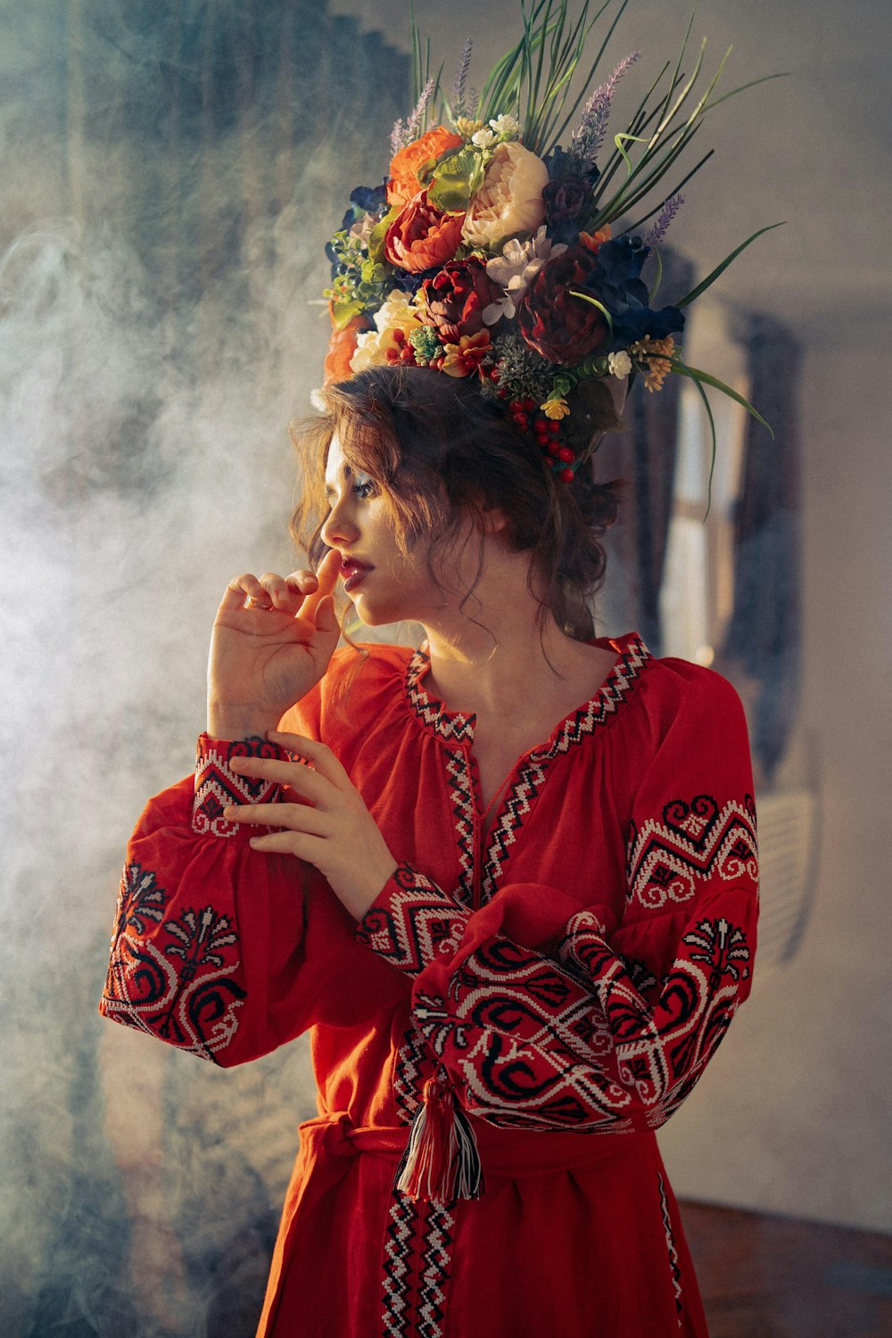 a woman in a red dress smoking a cigarette