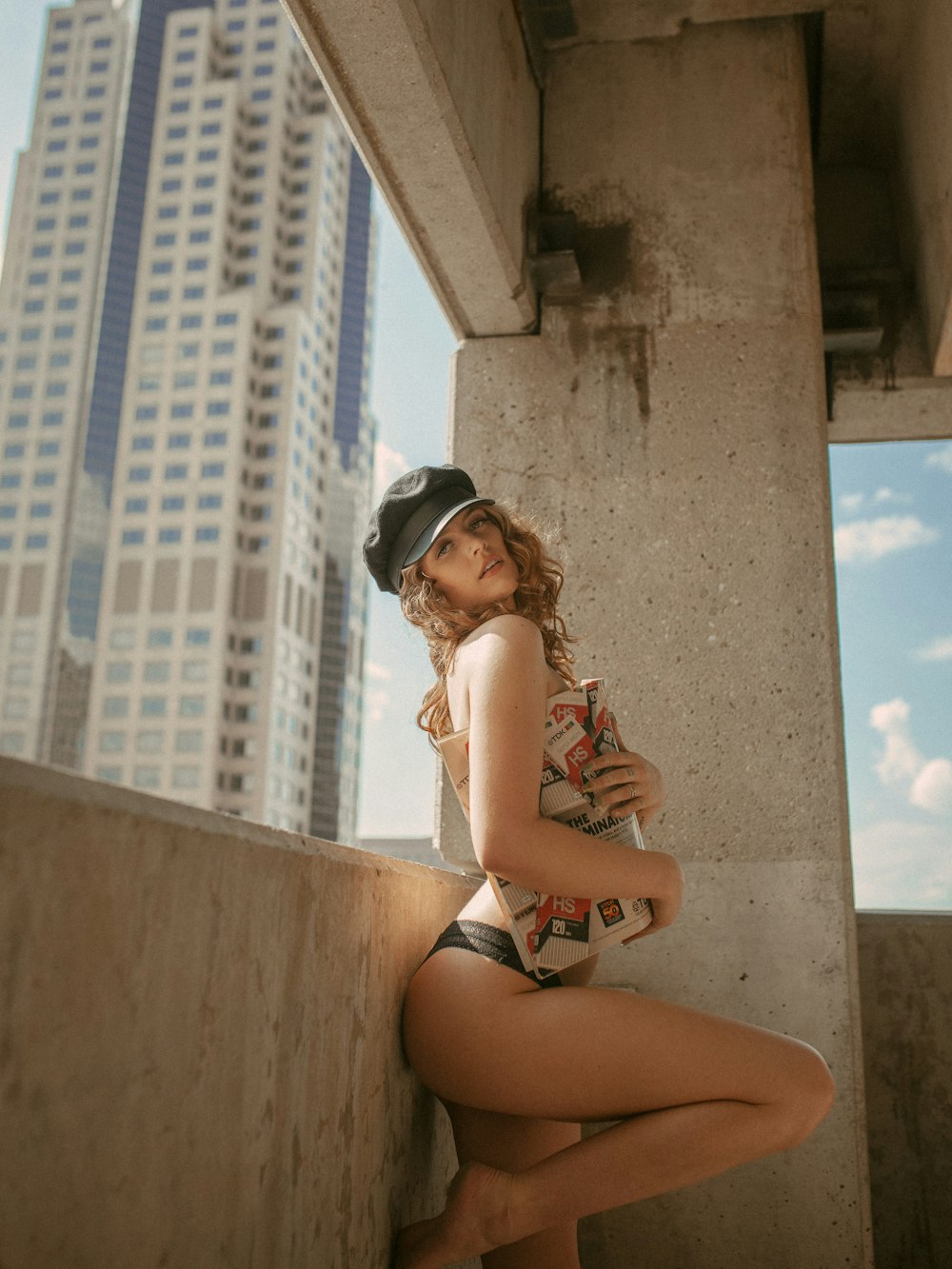 a woman in a bathing suit leaning against a wall