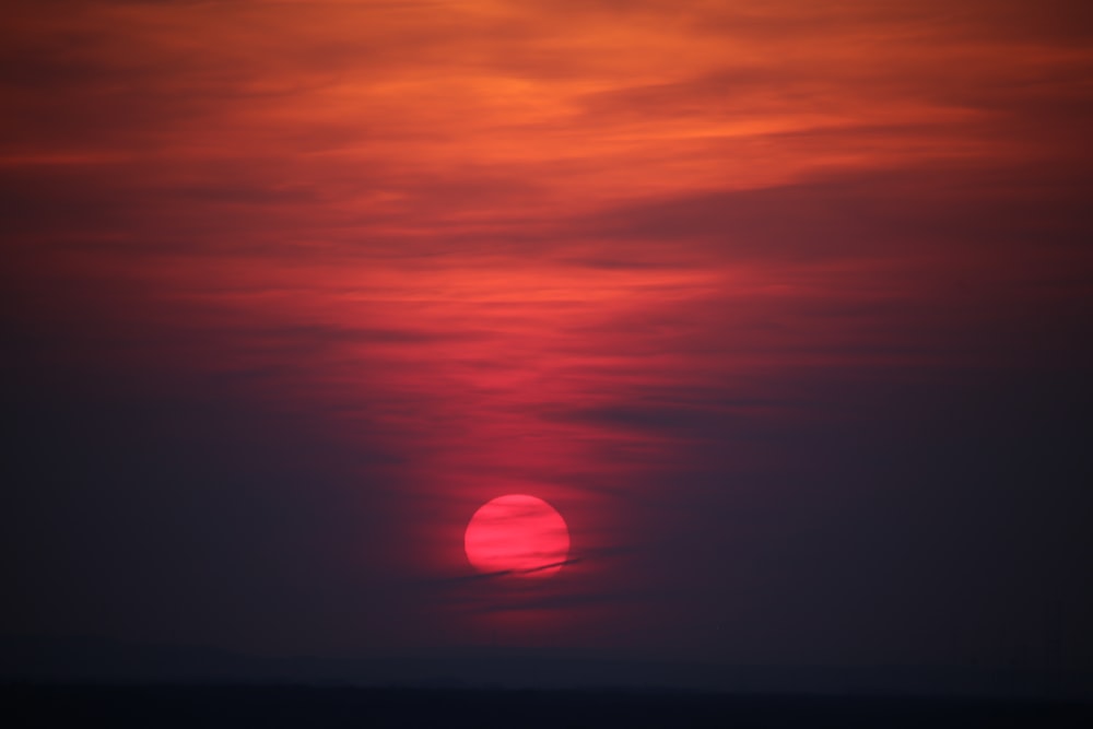 the sun is setting over the horizon of the ocean