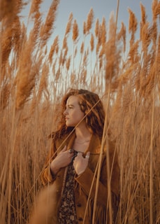 a woman standing in a field of tall grass