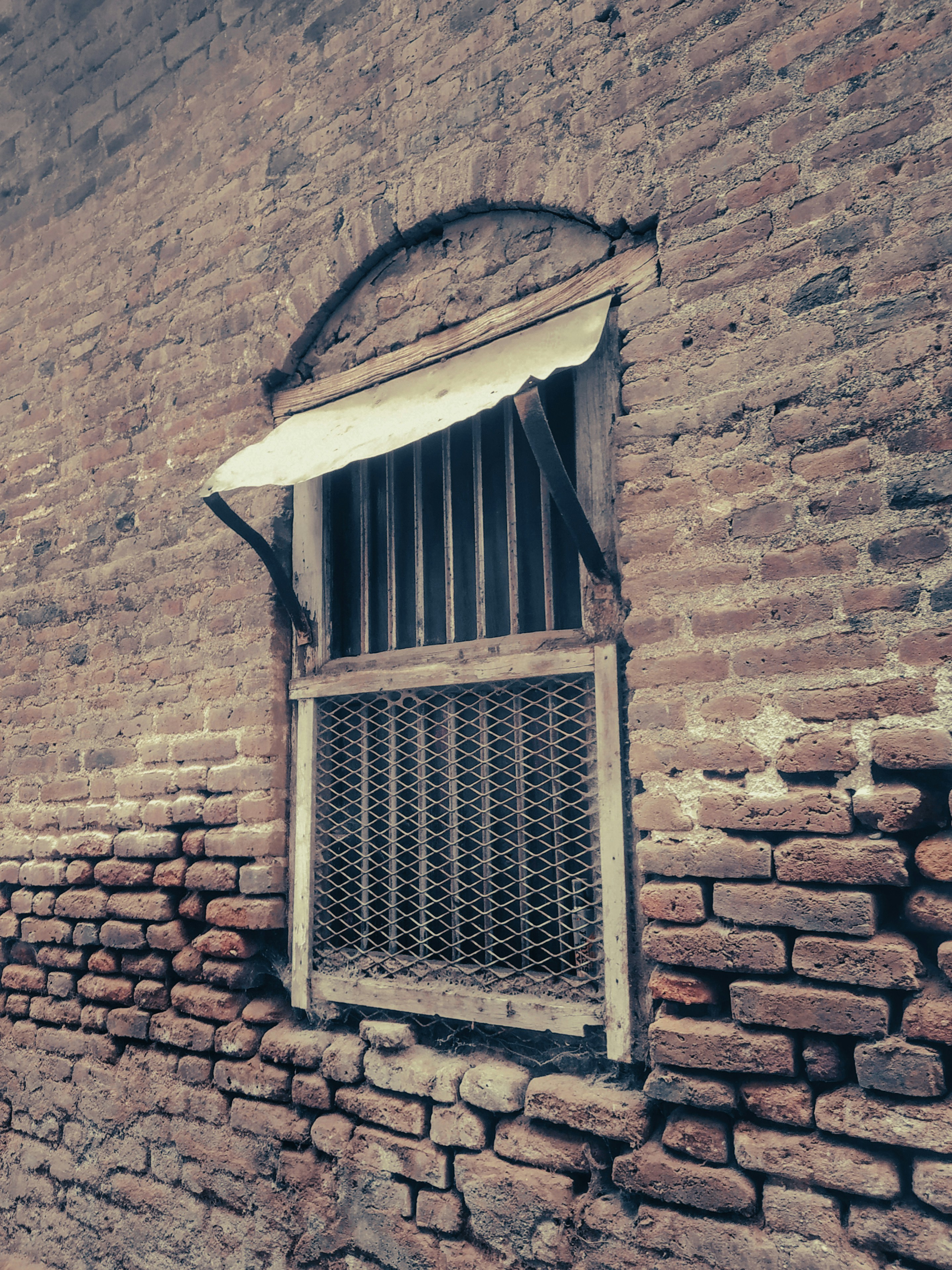 a brick building with a barred window and bars