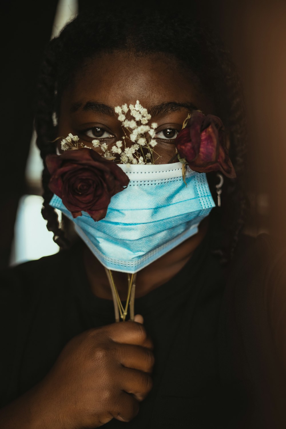 a woman wearing a face mask with flowers on it