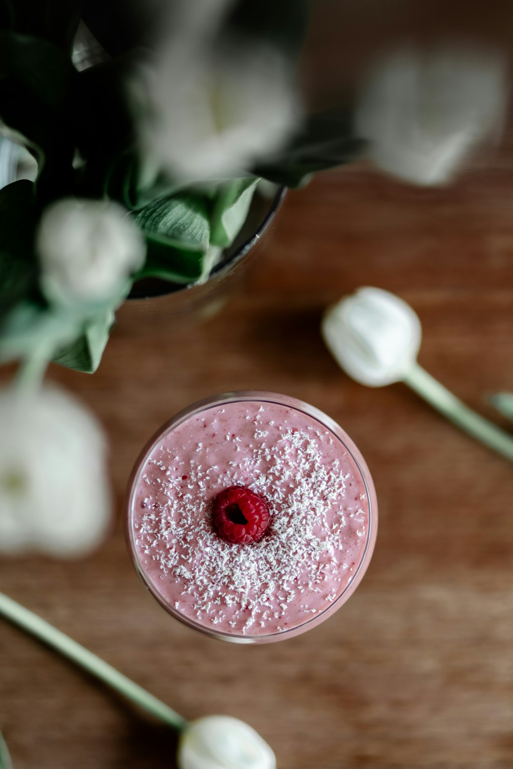 a pink drink sitting on top of a wooden table