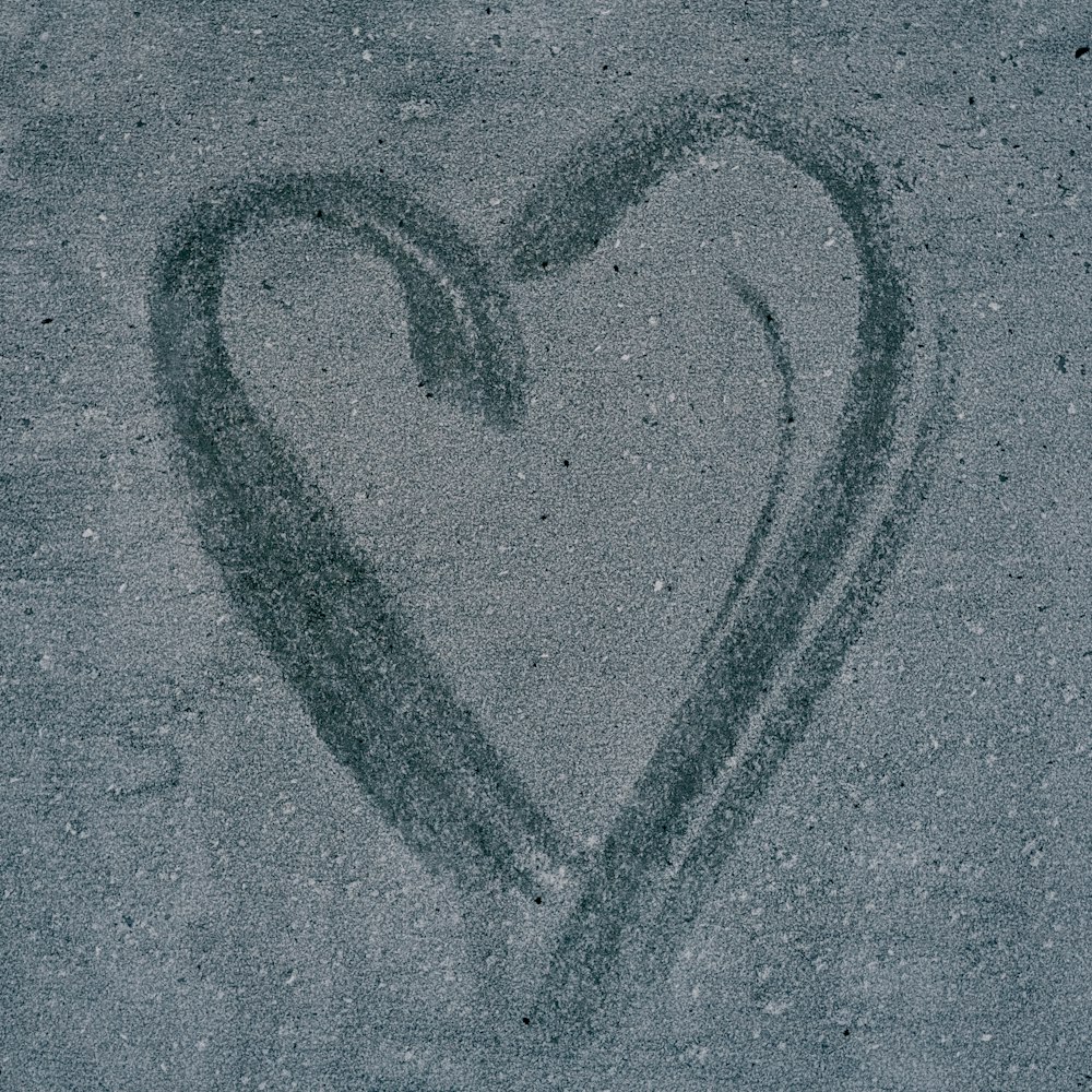 a heart drawn in the sand on the beach