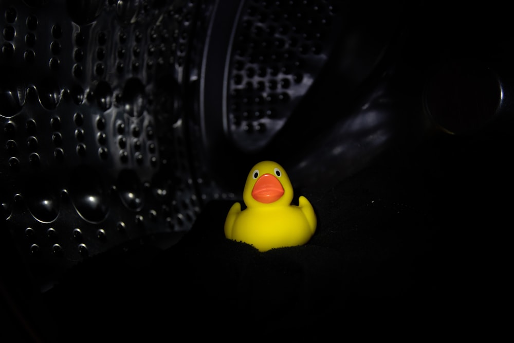 a yellow rubber ducky sitting in the dark