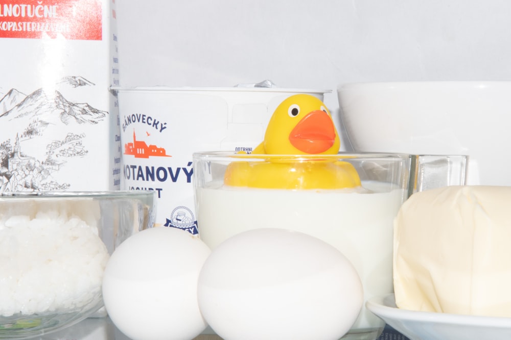 a yellow rubber duck in a bathtub surrounded by ingredients