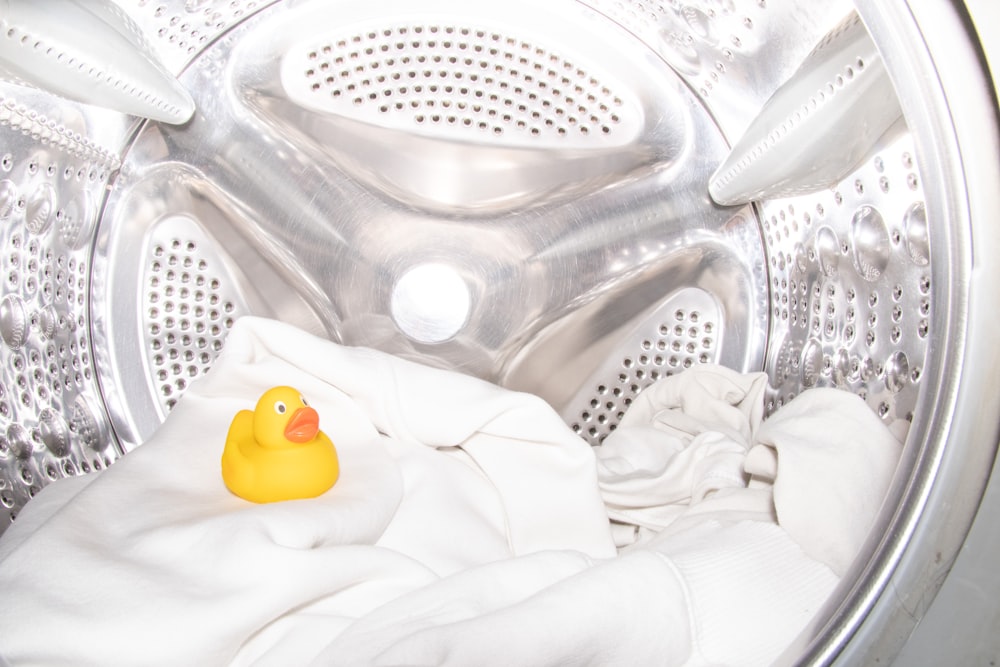 a rubber ducky toy sitting inside of a washing machine