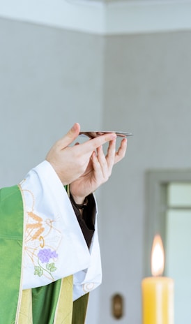 a person in a priest's robe holding a cell phone