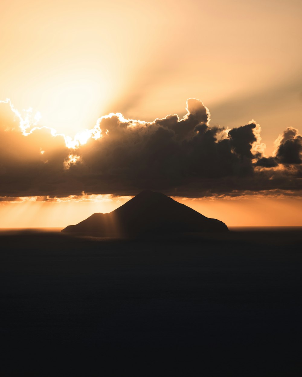 the sun is setting over a small island